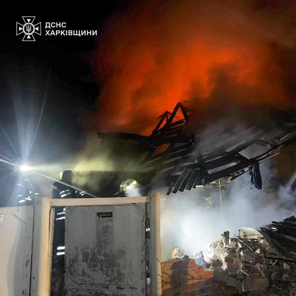 Firefighters working at the site of a Russian drone strike on Feb 11 that killed a father, his two-year-old twin sons and one year-old daughter. The man's pregnant wife survived the attack in Ukraine's Kharkiv region.