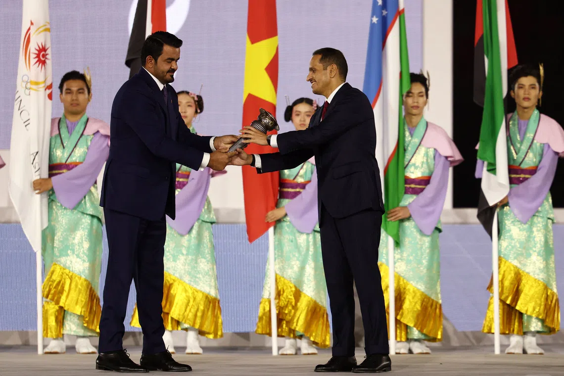Olympic Council of Asia president Sheikh Joaan bin Hamad Al Thani passes on the torch to Qatar’s Prime Minister Sheikh Mohammed bin Abdulrahman Al Thani during the closing ceremony. Doha will host the Games in 2030.