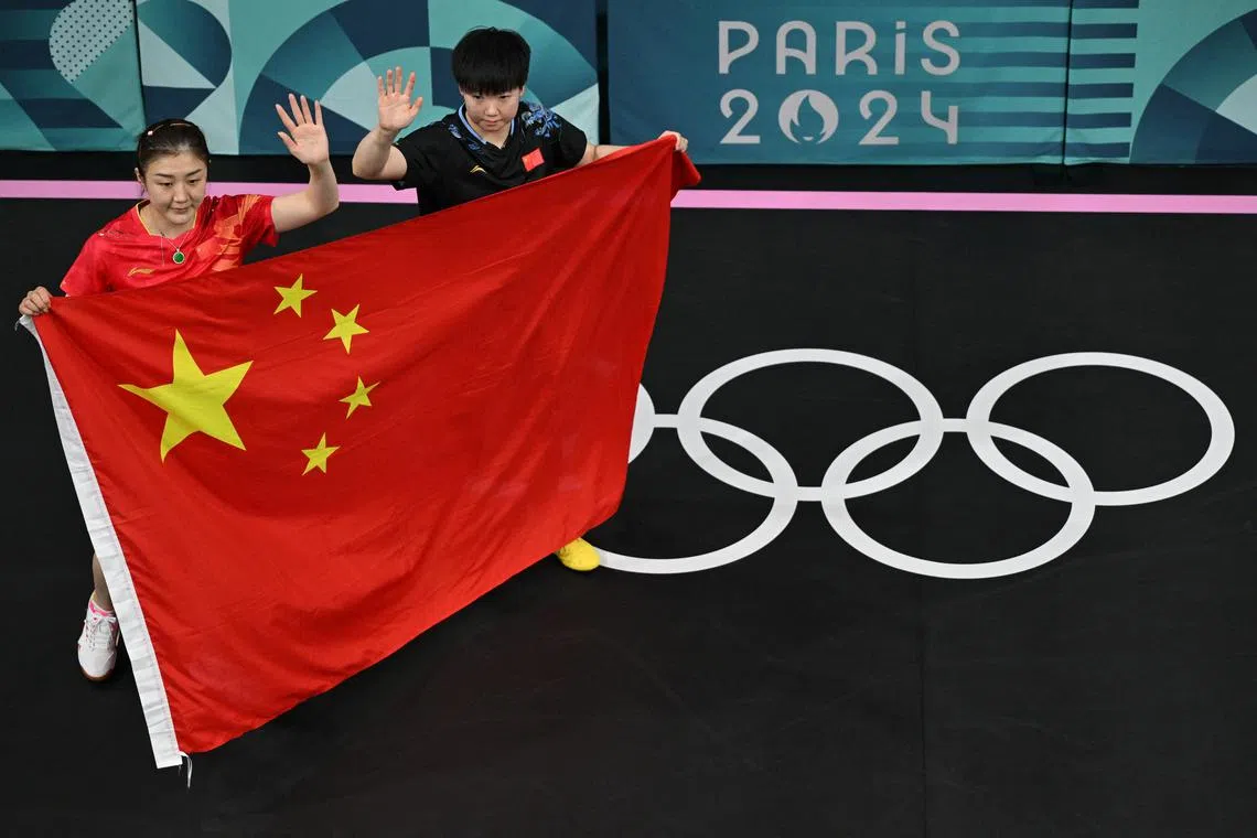 FILE PHOTO: Paris 2024 Olympics - Table Tennis - Women's Singles Gold Medal Match - South Paris Arena 4, Paris, France - August 03, 2024. Meng Chen of China and Yingsha Sun of China pose with the flag of China after winning their gold medal match. Pool via REUTERS/Antonin Thuillier/File Photo