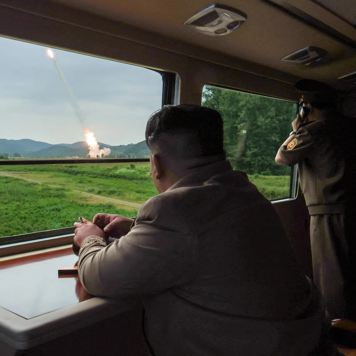 North Korean leader Kim Jong Un oversees the test-firing of a new 600mm multiple rocket launcher at an undisclosed location in North Korea.