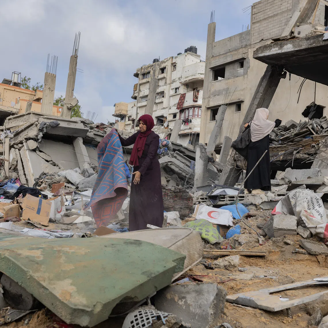 People salvage what they can from the wreckage of a building in Gaza City after an Israeli airstrike on July 30.