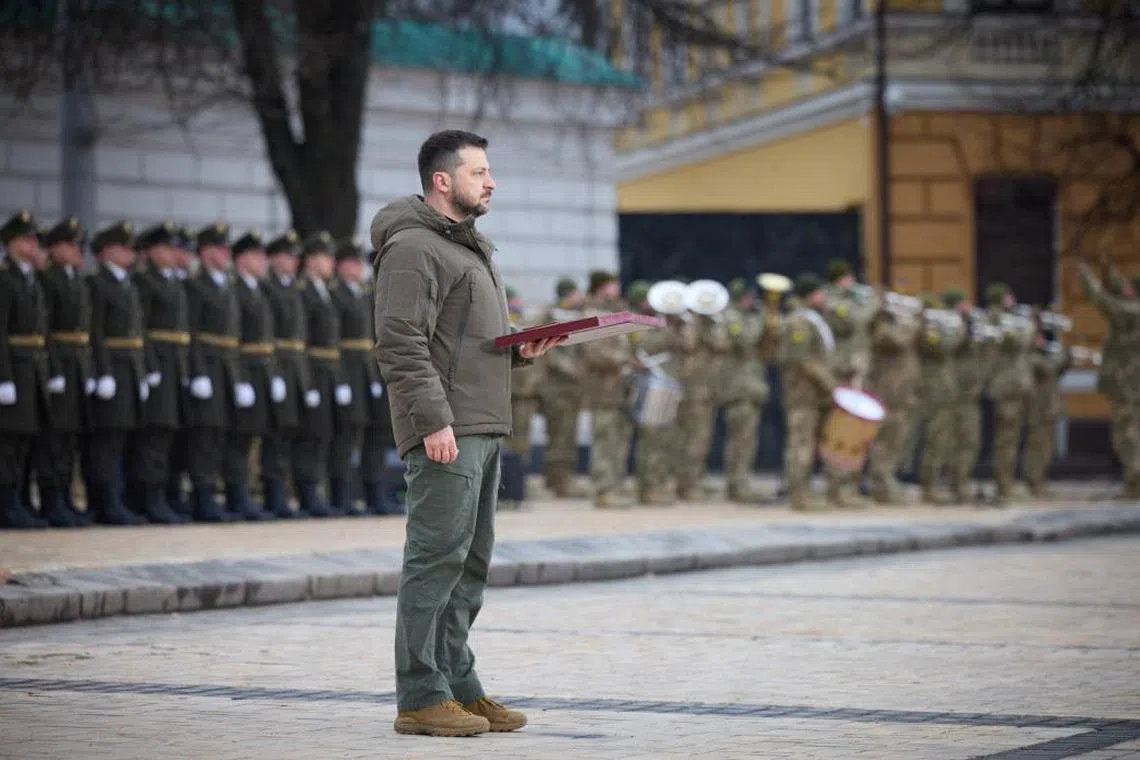 In Kyiv’s St Sophia Square, President Volodymyr Zelensky bestowed medals on soldiers, fighting back tears as the national anthem was played.