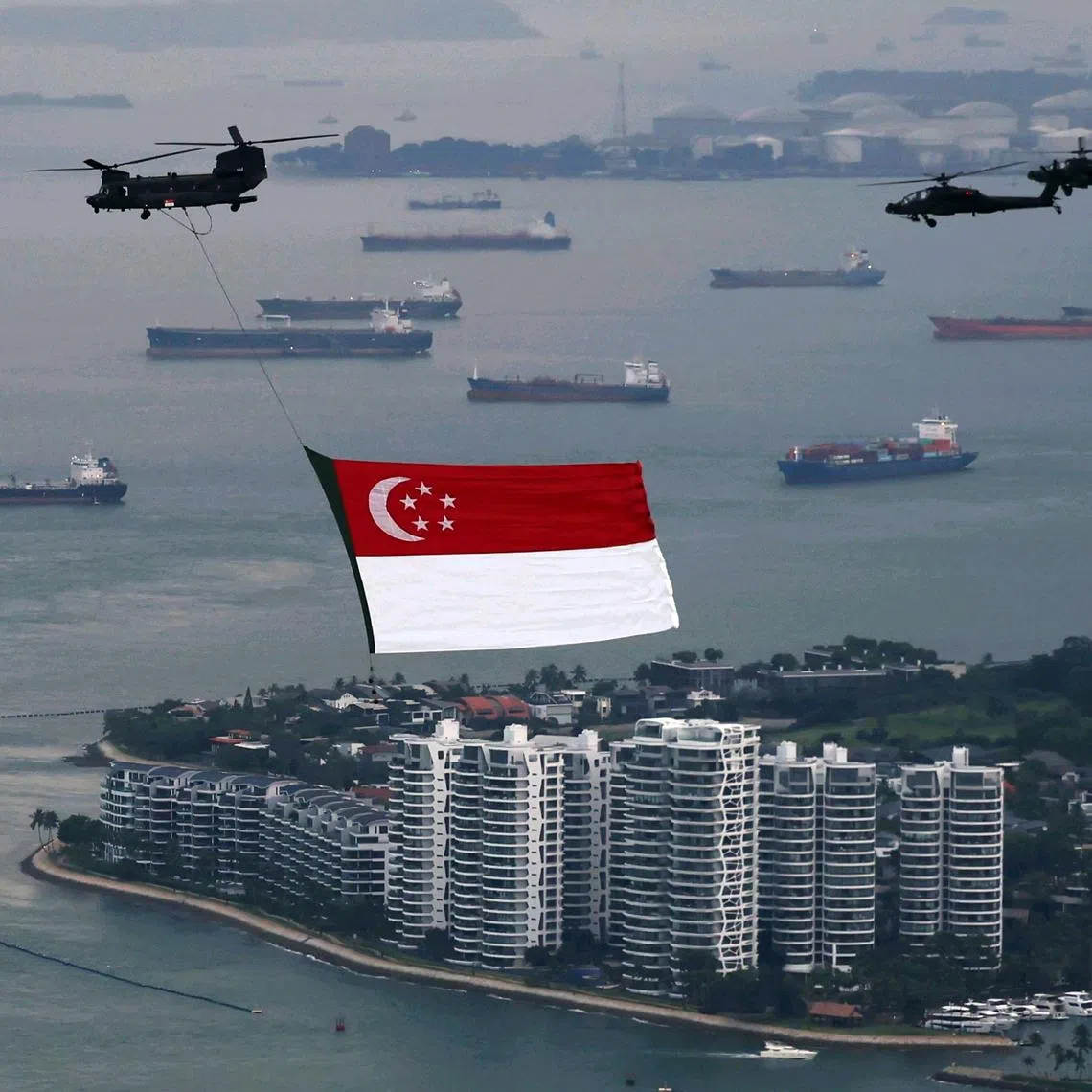 The CH-47 Chinook heavy-lift helicopter, escorted by two AH-64D Apache attack helicopters, waiting to make its entry towards National Stadium for the state flag fly-past rehearsal on July 4.