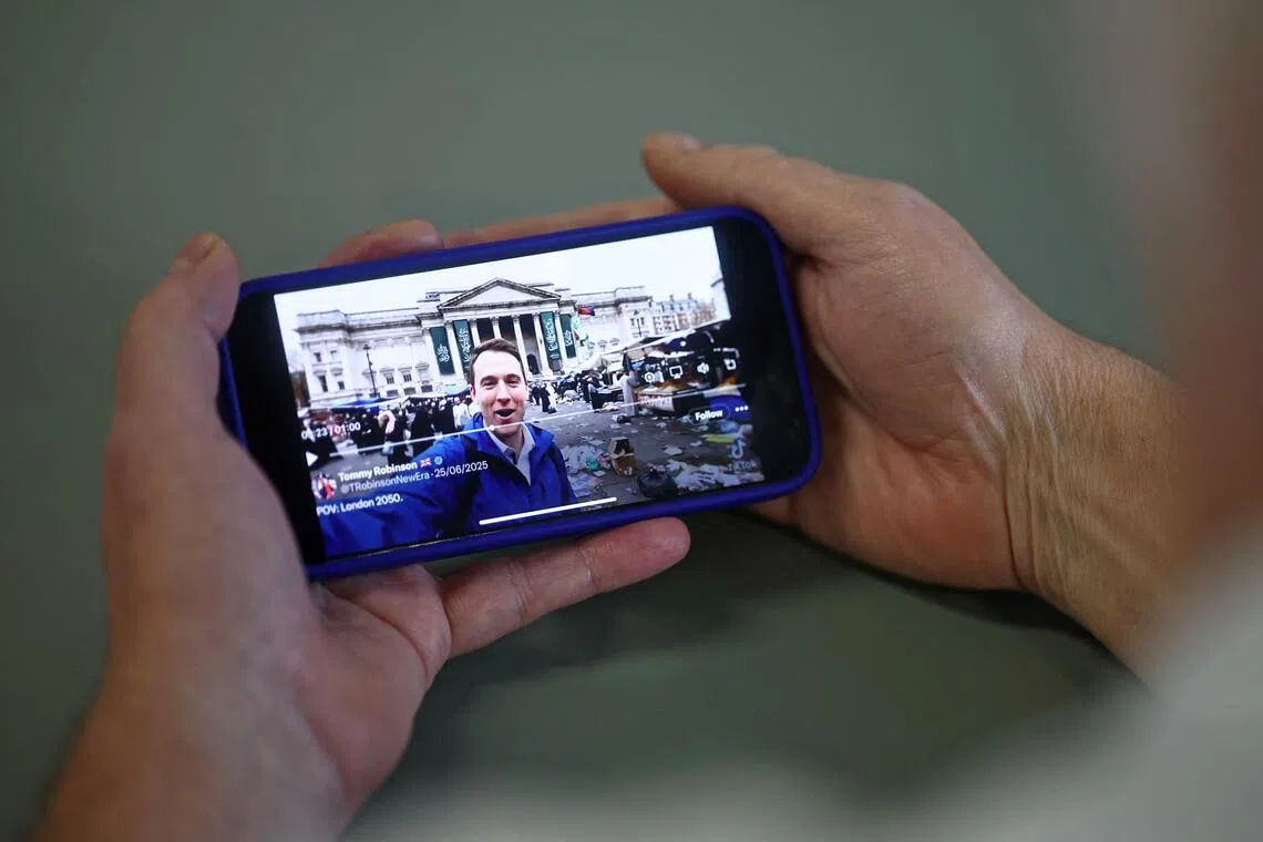 An AI-generated video of London in decline, shared on the social media site X account of British far-right activist Tommy Robinson, whose real name is Stephen Yaxley-Lennon, is viewed on a smart phone in London on Oct 10, 2025. 