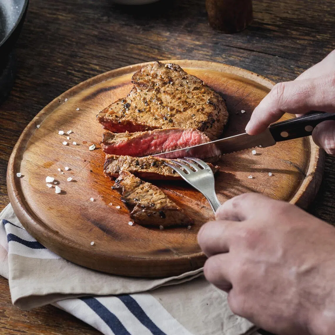 CMG0414 Yy / 秀慧 / Man is eating grilled steak at a wooden table. Dinner table concept