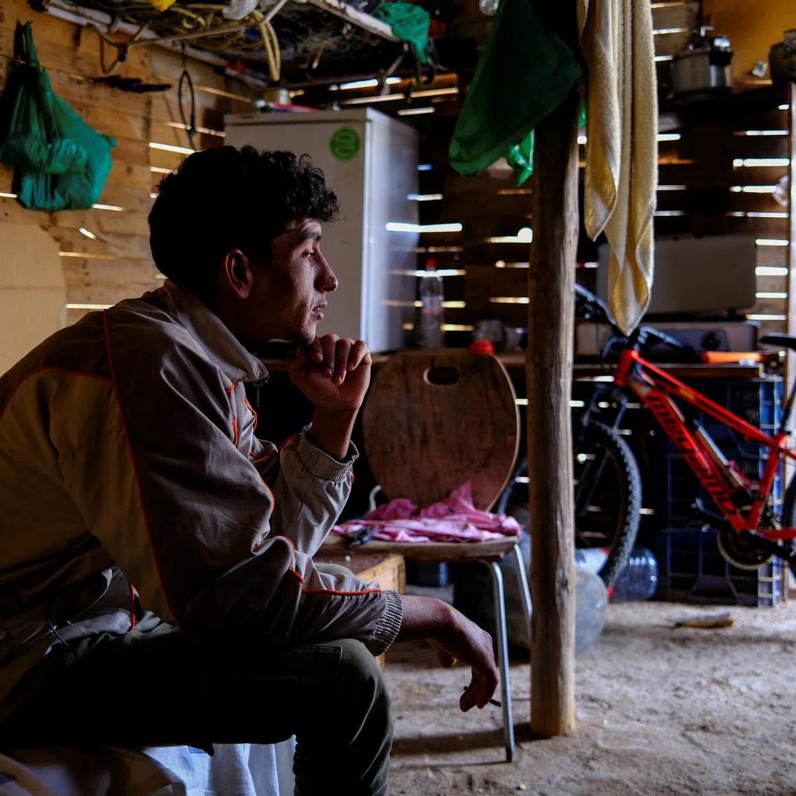 Moroccan migrant Abdelmoujoud Erra, 27, sits on a bed at a shack friend’s near the site where the place they lived burned in a fire in Nijar, province of Almeria Spain, April 21, 2026. Erra says \"Documents needed for a migration amnesty were saved because they were stored at a Red Cross facility\". REUTERS/Nacho Doce