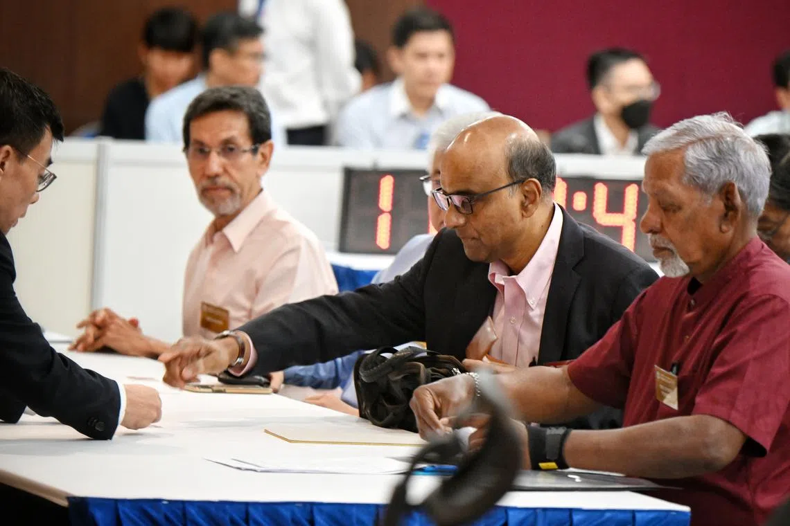 Tharman Shanmugaratnam submitting his nomination papers to the returning officer in the nomination hall.