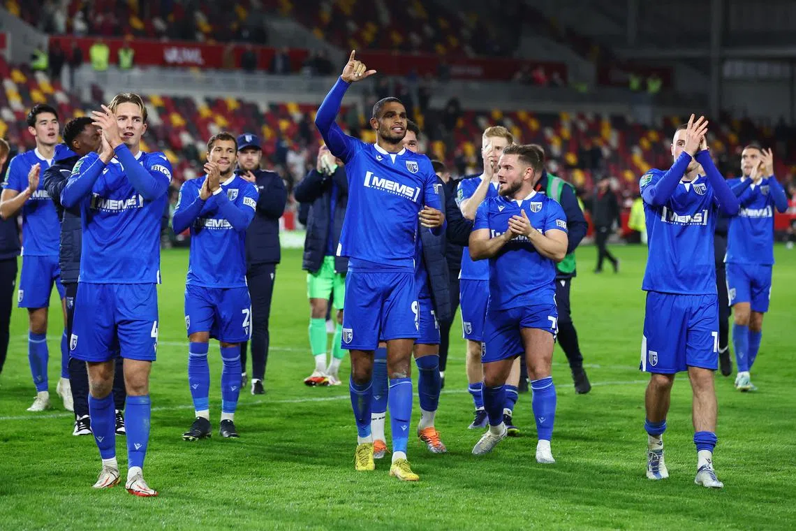 Gillingham's Mikael Mandron celebrating with teammates after winning the penalty shootout for the fourth-tier side, who stunned Premier League club Brentford in the League Cup on Tuesday.