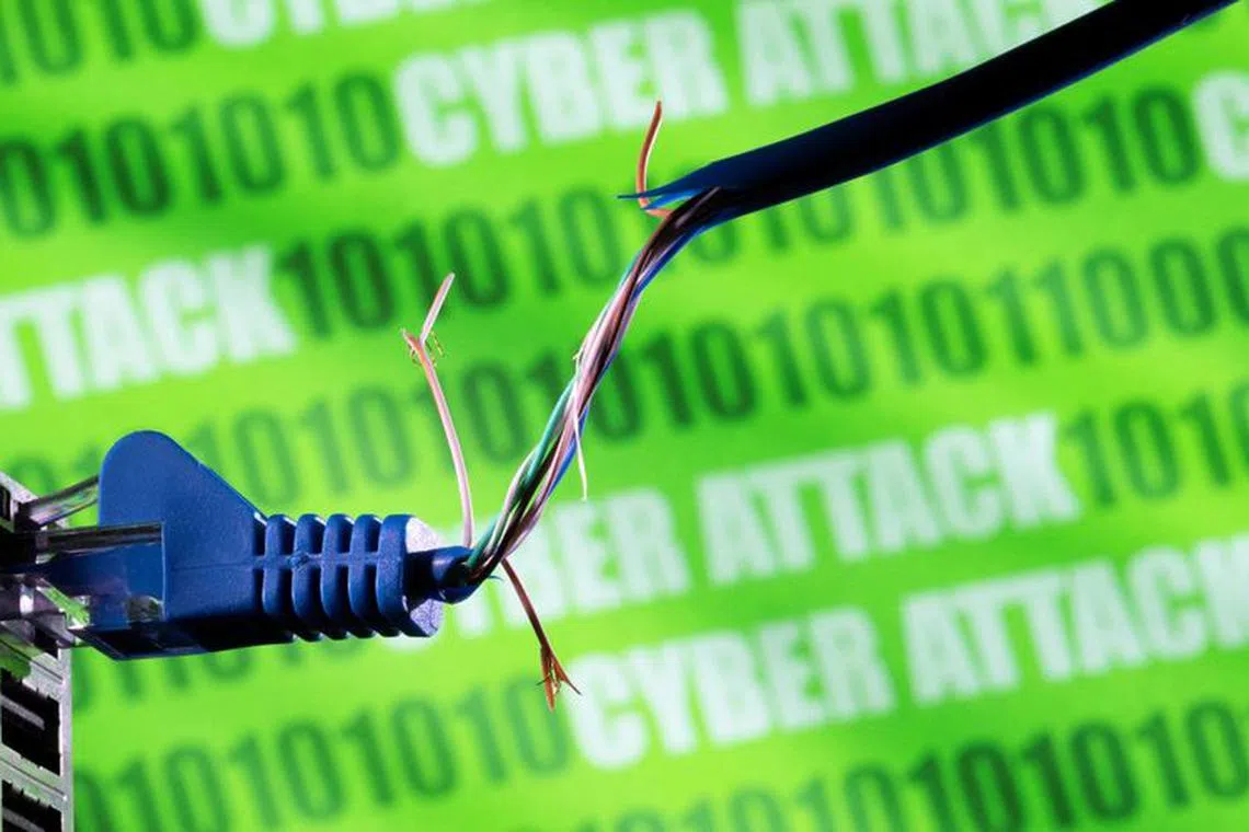 FILE PHOTO: Broken Ethernet cable is seen in front of binary code and words \"cyber attack\" in this illustration taken March 8, 2022. REUTERS/Dado Ruvic/Illustration/File Photo