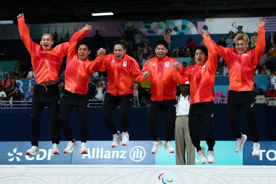 The Japanese team celebrating on the podium after beating Ukraine 4-3 in goalball to win their first Paralympic gold in the sport.
