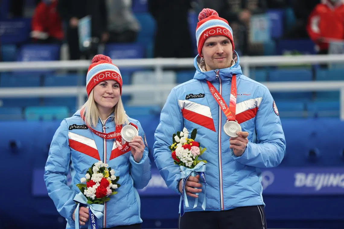 2022 Beijing Olympics - Curling - Victory Ceremony - Curling Mixed Doubles MD Gold Medal - National Aquatics Center, Beijing, China - February 8, 2022. Silver medallists Kristin Skaslien of Norway and Magnus Nedregotten of Norway pose on the podium. REUTERS/Eloisa Lopez