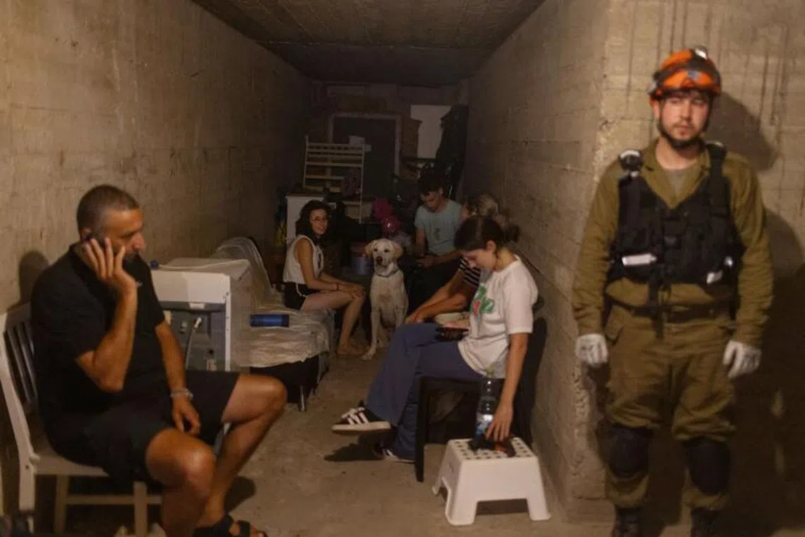 Israelis take shelter after a siren was heard near a building that was hit by a ballistic missile launched from Iran in Bat Yam, Israel, on Sunday, June 15, 2025.  Israel and Iran continued intense bombardments on one another’s territories for the third day, with no sign of a reprieve and growing concerns over a wider conflict in one of the world’s key oil-producing regions. Photographer: Kobi Wolf/Bloomberg