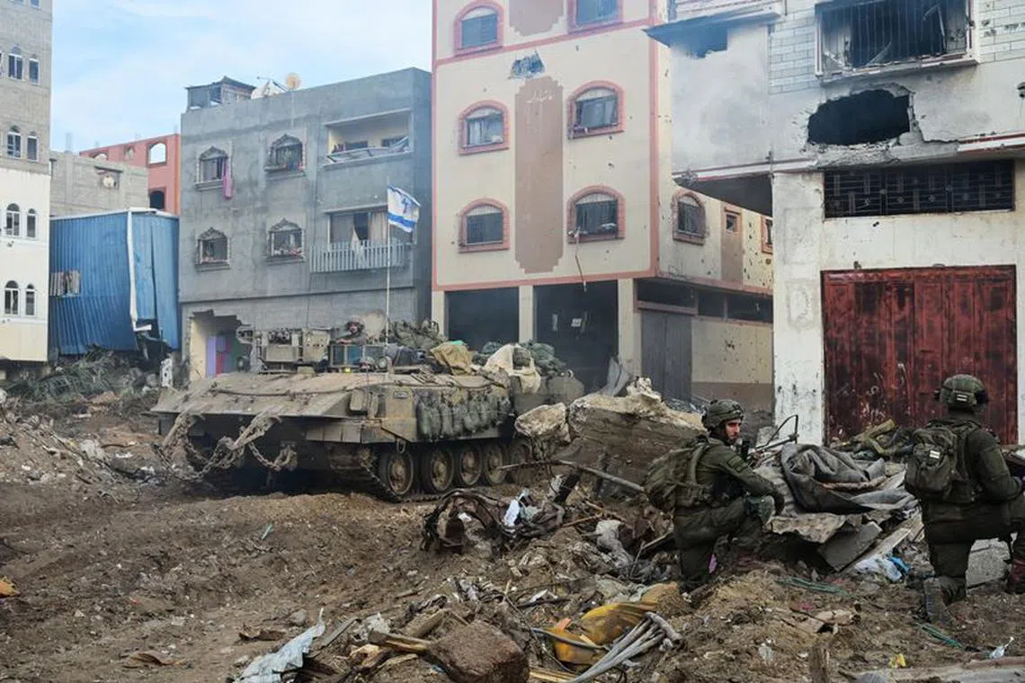 Israeli soldiers operate with an APC at the Shajaiya district of Gaza city amid the ongoing conflict between Israel and the Palestinian Islamist group Hamas, in the Gaza Strip December 8, 2023.  REUTERS/Yossi Zeliger