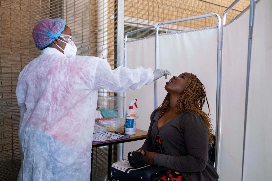 A healthcare worker conducts a PCR Covid-19 test at the Lancet laboratory in Johannesburg on November 30, 2021. - A new, heavily mutated Covid-19 variant, dubbed omicron, spread across the globe on Sunday, shutting borders and renewing curbs as the EU chief said governments faced a "race against time" to understand the strain (Photo by EMMANUEL CROSET / AFP)