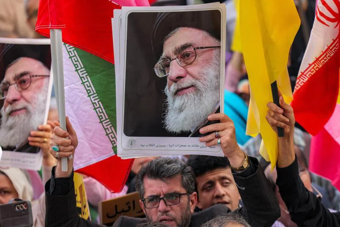 A demonstrator holds a picture of Iran's Supreme Leader Ayatollah Ali Khamenei during a rally in Tehran on June 14.