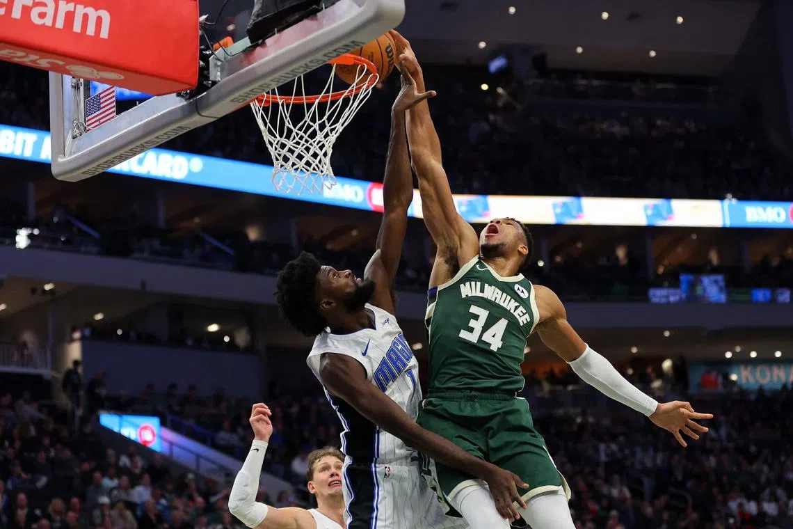 Giannis Antetokounmpo of the Milwaukee Bucks is fouled by Jonathan Isaac of the Orlando Magic during the first half at Fiserv Forum.