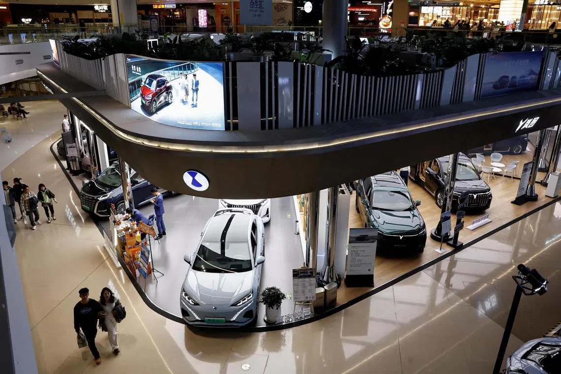 FILE PHOTO: Electric vehicle (EV) models are displayed at the booths of Denza, a joint venture between Mercedes-Benz Group AG and BYD Auto, and Chinese EV maker Voyah, at a shopping mall in Beijing, China November 3, 2023. REUTERS/Tingshu Wang/File Photo