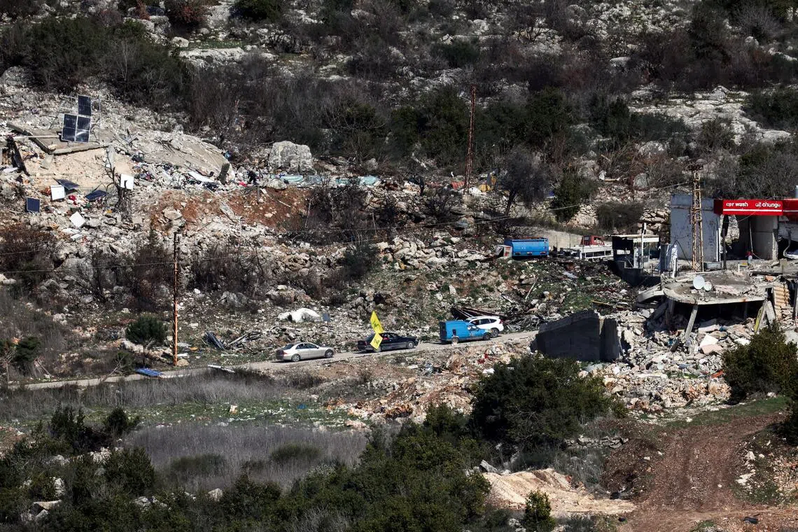 FILE PHOTO: Lebanese vehicles drive past damaged buildings in southern Lebanon, as seen from northern Israel, after a ceasefire between Israel and Hezbollah took effect, January 27, 2025. REUTERS/Ronen Zvulun/File Photo