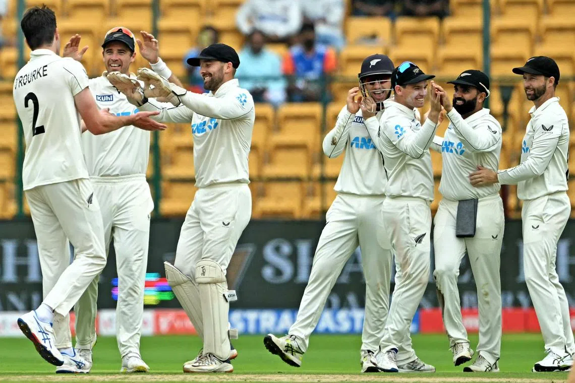 New Zealand's players celebrate after the dismissal of India's K.L. Rahul on the second day of the first cricket Test against India at the M. Chinnaswamy Stadium in Bengaluru on Oct 17, 2024.