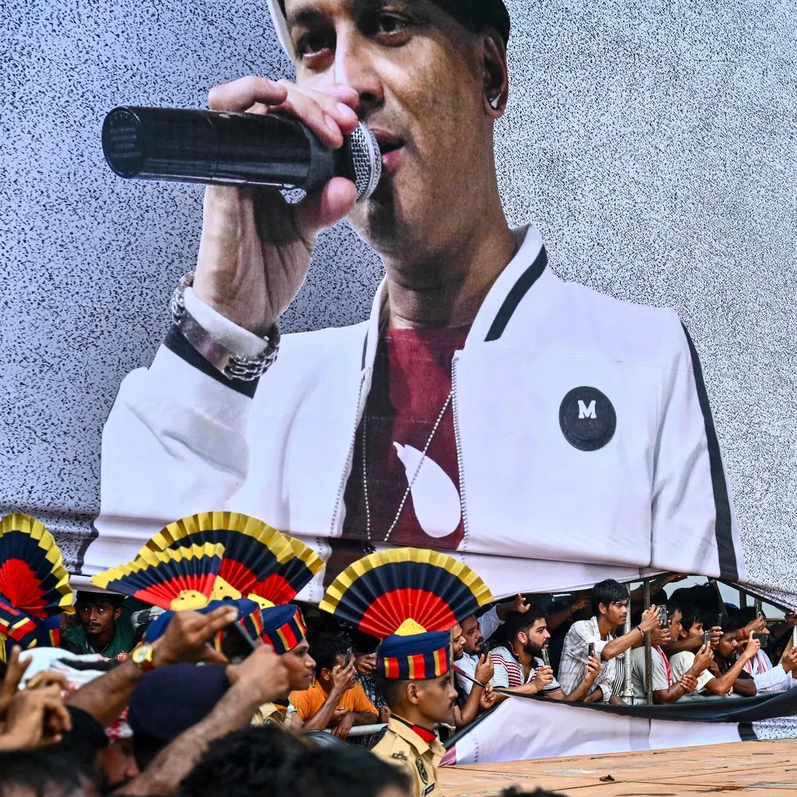 TOPSHOT - Fans throng during the cremation of Indian musician Zubeen Garg, on the outskirts of Guwahati on September 23, 2025. Zubeen Garg, 52, died by drowning in Singapore last week, triggering a massive outpouring of grief among his millions of fans in Assam, where he enjoyed a cult-like status. Tens of thousands of mourners thronged the streets of India's northeastern Assam state on September 23 to bid farewell to a flamboyant artiste, celebrated as much for his music as for his irreverent persona. (Photo by Biju BORO / AFP)