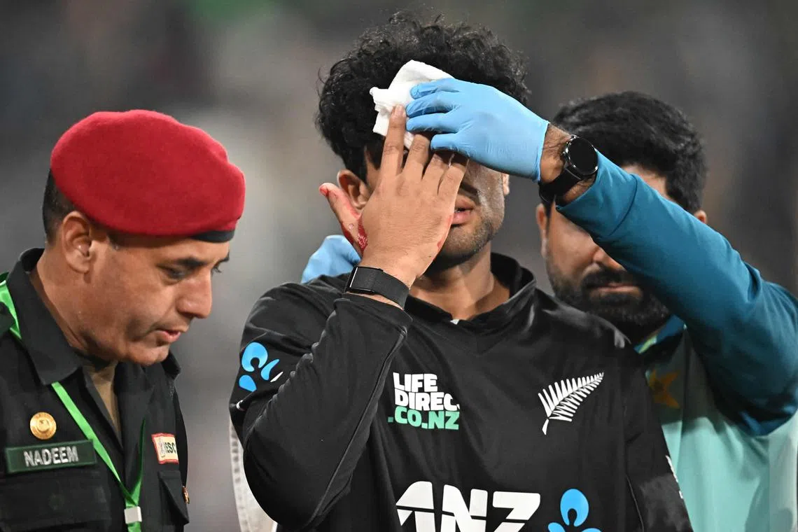 New Zealand's Rachin Ravindra receives medical attention after being hit on the head by the ball in the Tri-Nations first one-day international cricket match against Pakistan at the Gaddafi Stadium in Lahore on Feb 8, 2025.