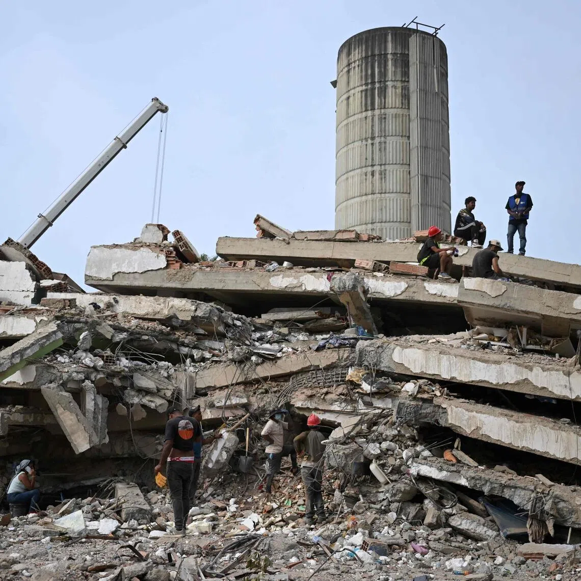 Workers remove debris from a collapsed building in Caraballeda, La Guaira state, Venezuela, on July 9, following the June 24 earthquakes.