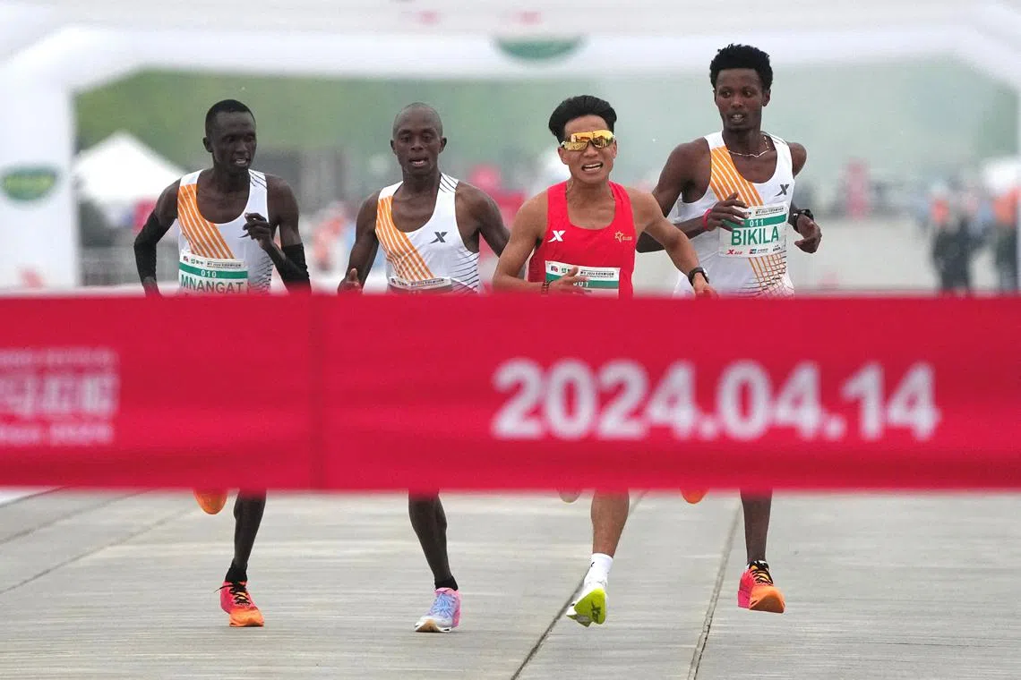 FILE PHOTO: Chinese runner He Jie, Ethiopian Dejene Hailu Bikila and Kenyans Robert Keter and Willy Mnangat take part in a half-marathon in Beijing, China April 14, 2024. cnsphoto via REUTERS/File Photo