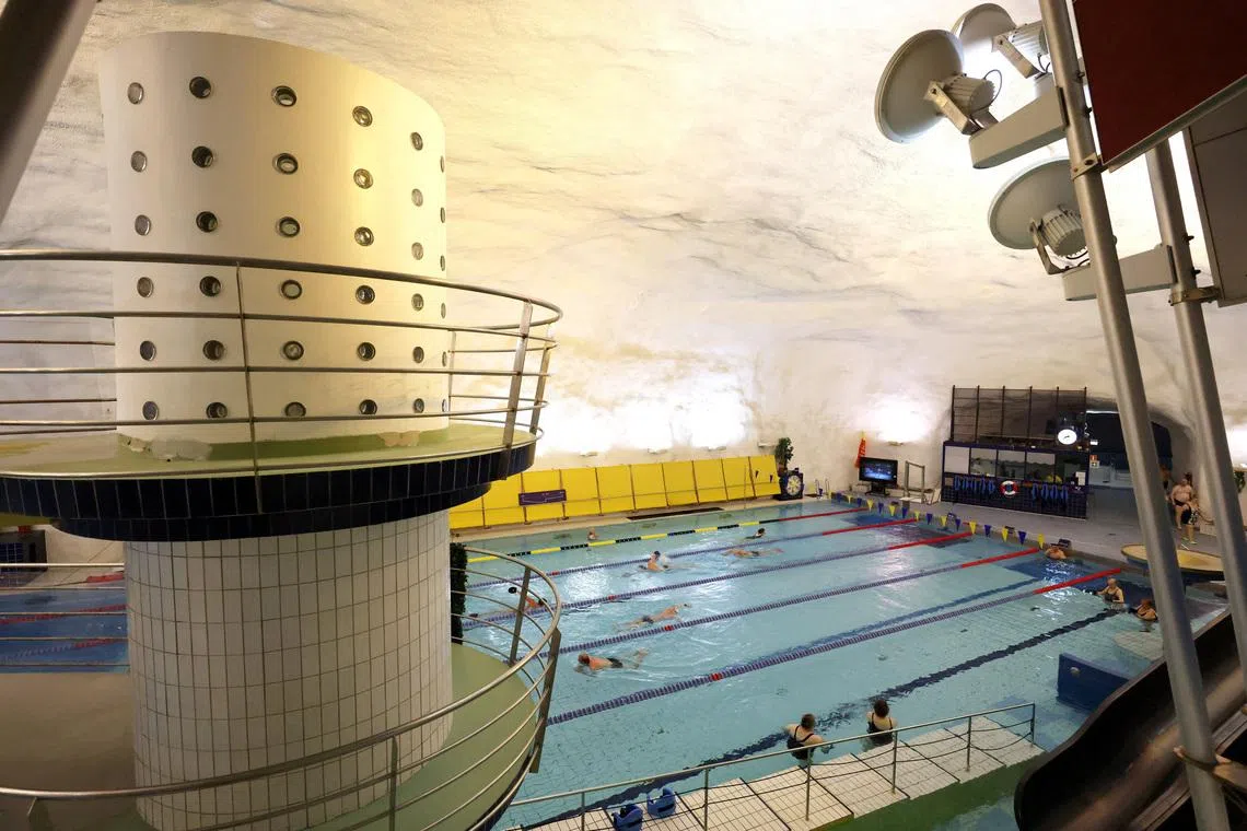People swim in Itäkeskus Swimming Hall, Helsinki's underground swimming pool carved into solid bedrock, which can be drained and converted into a bomb shelter for 3,800 people, in Helsinki, Finland, May 6, 2026. REUTERS/Leonhard Foeger