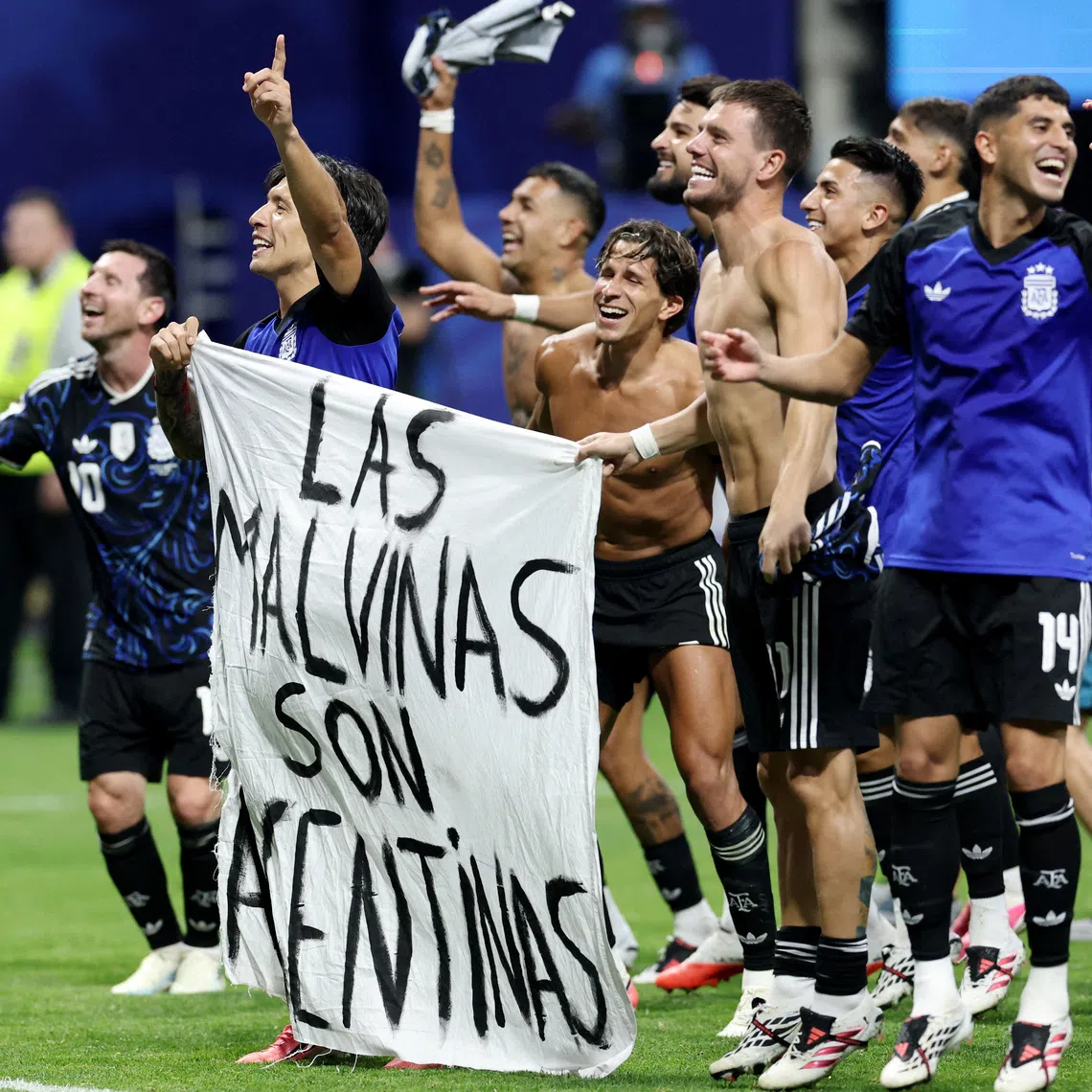 Soccer Football - FIFA World Cup 2026 - Semi Final - England v Argentina - Atlanta Stadium, Atlanta, Georgia, U.S. - July 15, 2026 Argentina's Lisandro Martinez and Giovani Lo Celso celebrate with a Falkland Islands related banner after the match as Argentina qualify for the final of the World Cup REUTERS/Amanda Perobelli