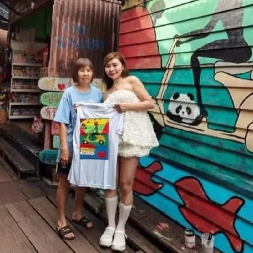 The Chinese artist, who goes by Shen Shishi online, posing with the owner of the building where she painted a panda.