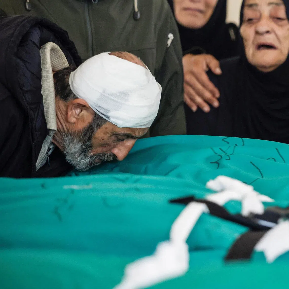 Mr Nasser Hussein Saeed, 64, kisses the body of his daughter Fatima, 39, during the funeral service of four members of his family, including his 1.5-year-old granddaughter Taleen, killed in an Israeli strike on Lebanon.