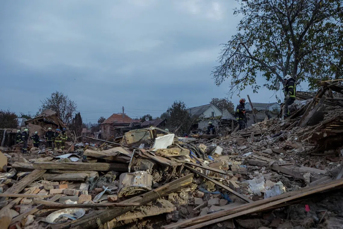 Rescuers work at a site of a private house which was hit by a Russian missile strike in Kharkiv, Ukraine on Oct 29.