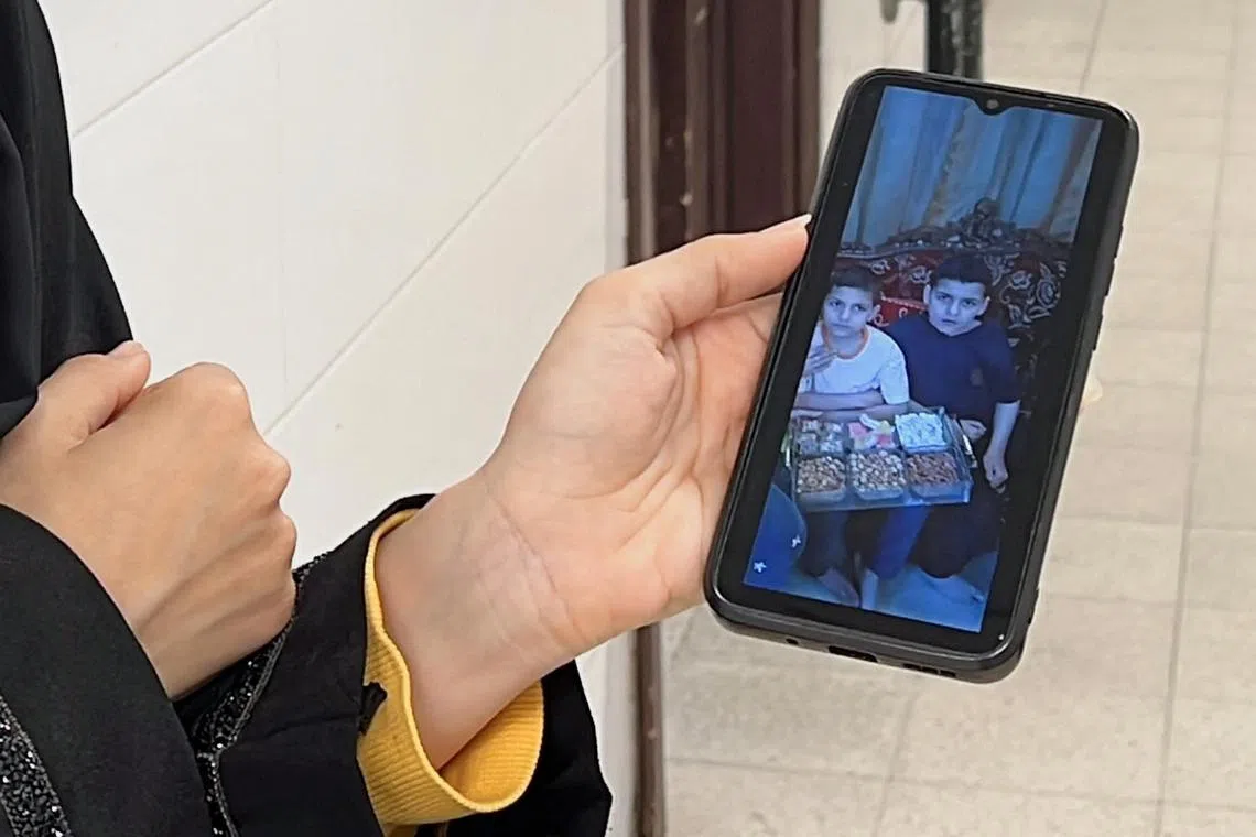 A Palestinian woman showing on her mobile phone children of the Al-Najjar family killed in an Israeli airstrike in Khan Younis, in the southern Gaza Strip, on May 24.