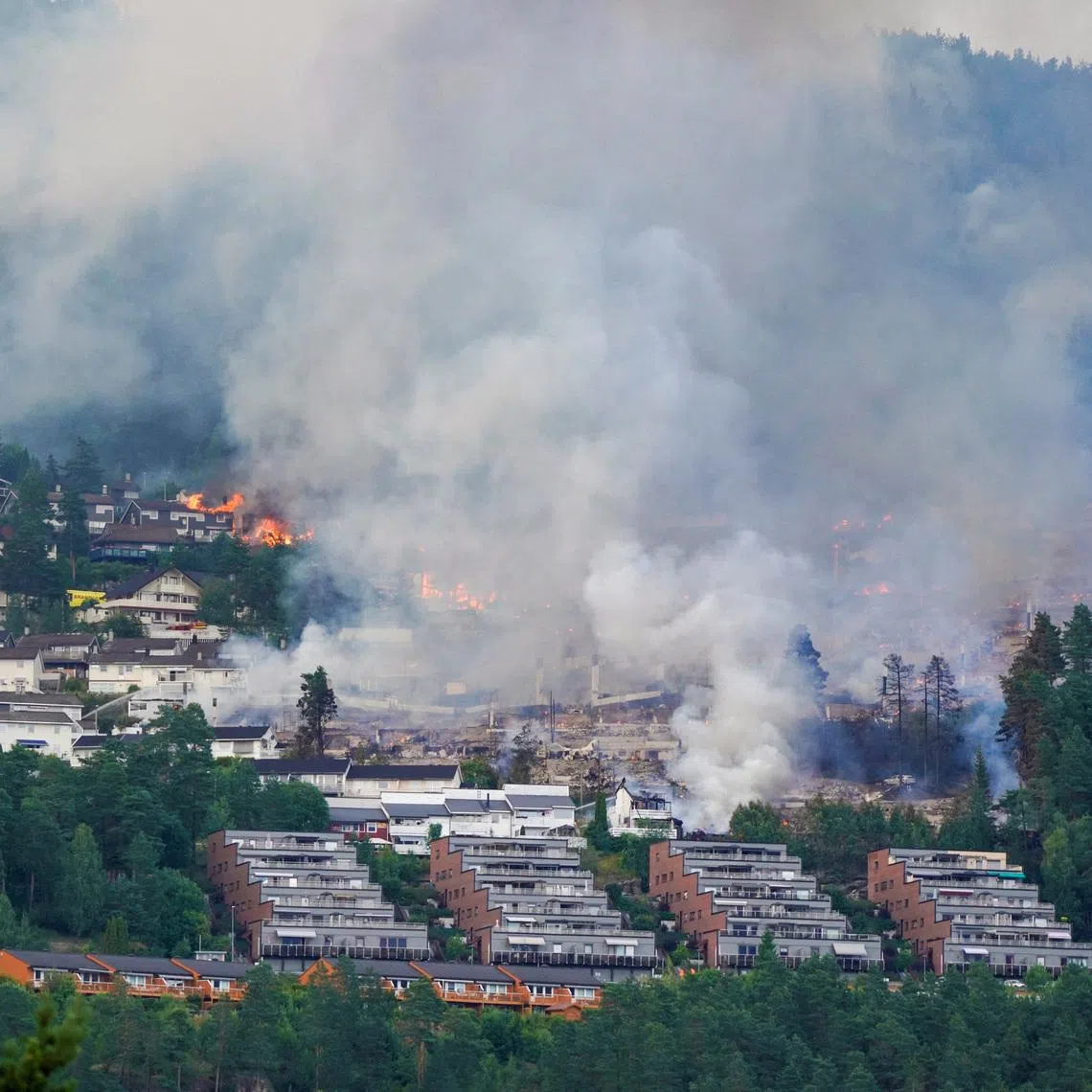 Smoke rises from a large fire that has spread from terraced houses in Krokstadelva, Drammen municipality, Norway, July 17, 2026. More than 50 homes were destroyed by fire on Friday near the city of Drammen in southern Norway as firefighters battled to contain the flames amid strong winds, rescue officials said. Thomas Fure/NTB/via REUTERS