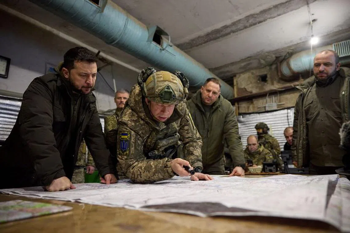 Ukraine's President Volodymyr Zelenskiy and Defence Minister Rustem Umerov listen to Commander of the Ground Forces colonel general Oleksandr Syrskyi as they visit a position of Ukrainian servicemen in the town of Kupiansk, amid Russia's attack on Ukraine, in Kharkiv region, Ukraine November 30, 2023.  Ukrainian Presidential Press Service/Handout via REUTERS