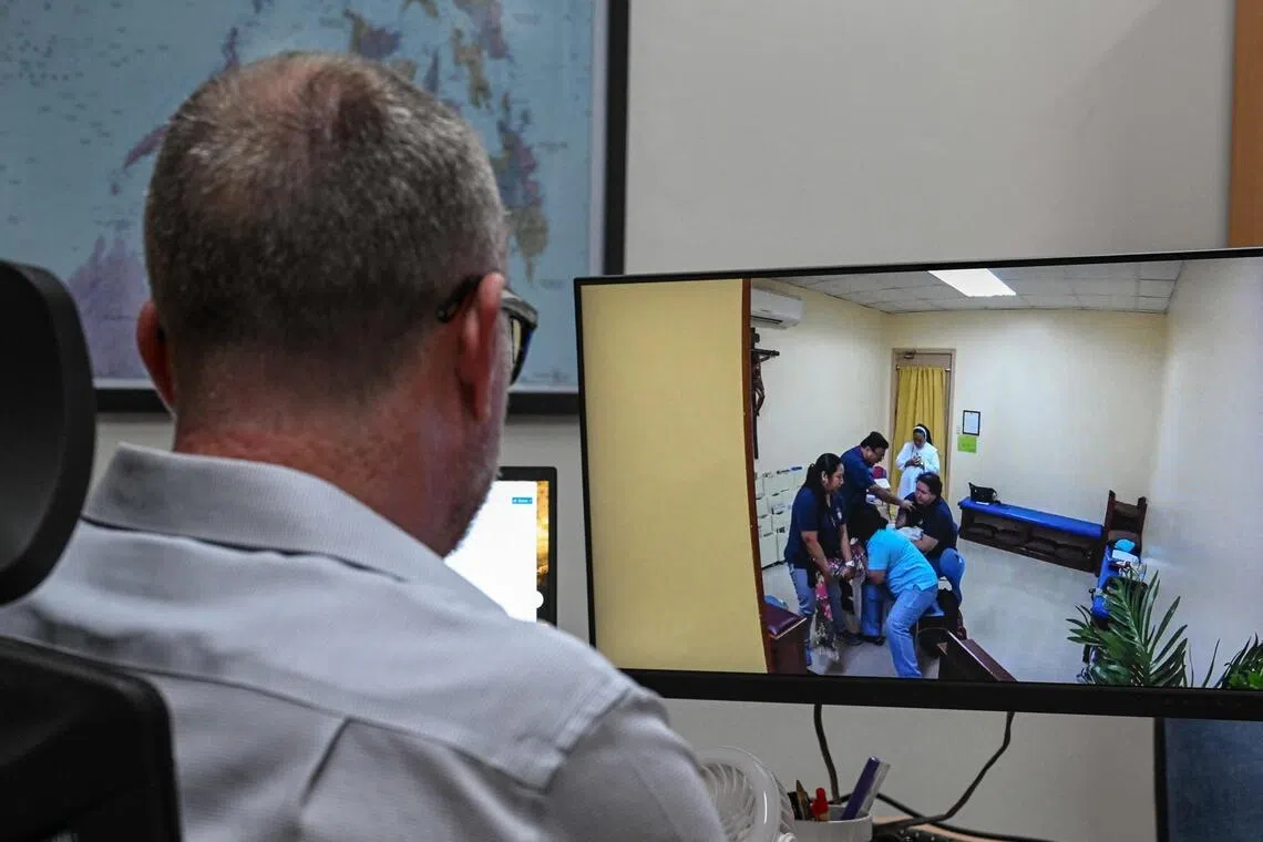 A man watching a footage of a woman being exorcised, in Makati, Metro Manila.