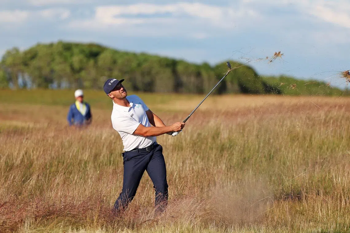 Jun 20, 2026; Southampton, New York, USA; Wyndham Clark hits a shot out of the high grass on the 13th fairway during the third round of the U.S. Open golf tournament at Shinnecock Hills Golf Club. Mandatory Credit: Bill Streicher-Imagn Images