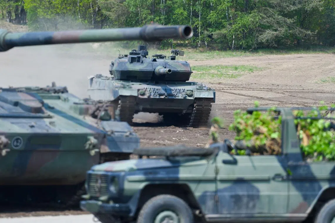 (FILES) This file photo taken on May 20, 2019 shows a Leopard 2 A7 main battle tank (background) of the German armed forces Bundeswehr taking part in an educational practice of the "Very High Readiness Joint Task Force" (VJTF) as part of the NATO tank unit at the military training area in Munster, northern Germany. - Germany on January 25, 2023 approved the delivery of Leopard 2 tanks to Ukraine, after weeks of pressure from Kyiv and many allies. Berlin will provide a company of 14 Leopard 2 A6 tanks from the Bundeswehr stocks and is also granting approval for other European countries to send tanks from their own stocks to Ukraine, a government spokesman said in a statement. (Photo by PATRIK STOLLARZ / AFP)