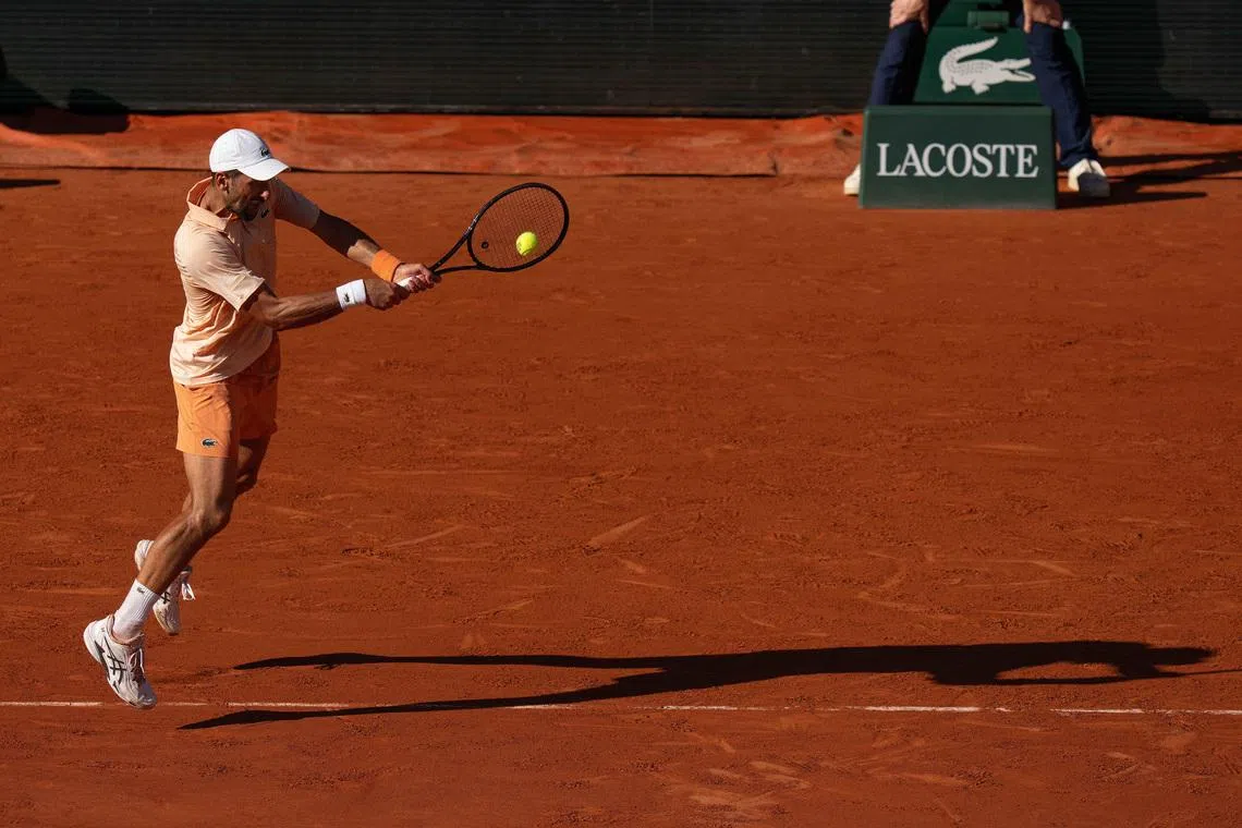 May 27, 2026; Paris, France; Novak Djokovic of Serbia returns a shot during his match against Valentin Royer of France on day four at Stade Roland Garros. Mandatory Credit: Susan Mullane-Imagn Images
