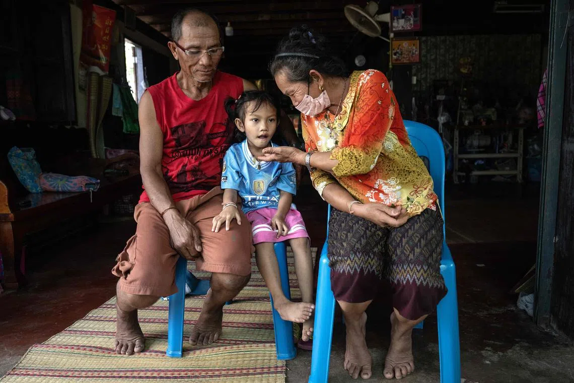 Paweenuch "Ammy" Supolwong (centre), who survived the nursery mass shooting, with her grandparents Yupin Srithong (right) and Somsak Srithong, at their family home.