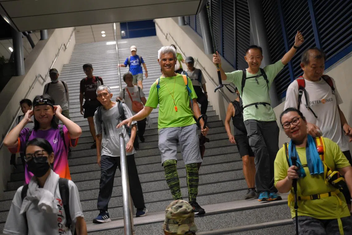 Tan Hock Seng (centre, in bright green), a 65-year-old stroke survivor, and other members of LongwalkSG, a walking group in Singapore, continue from their rest stop at Gul Circle MRT Station during their overnight walk on April 9, 2024.