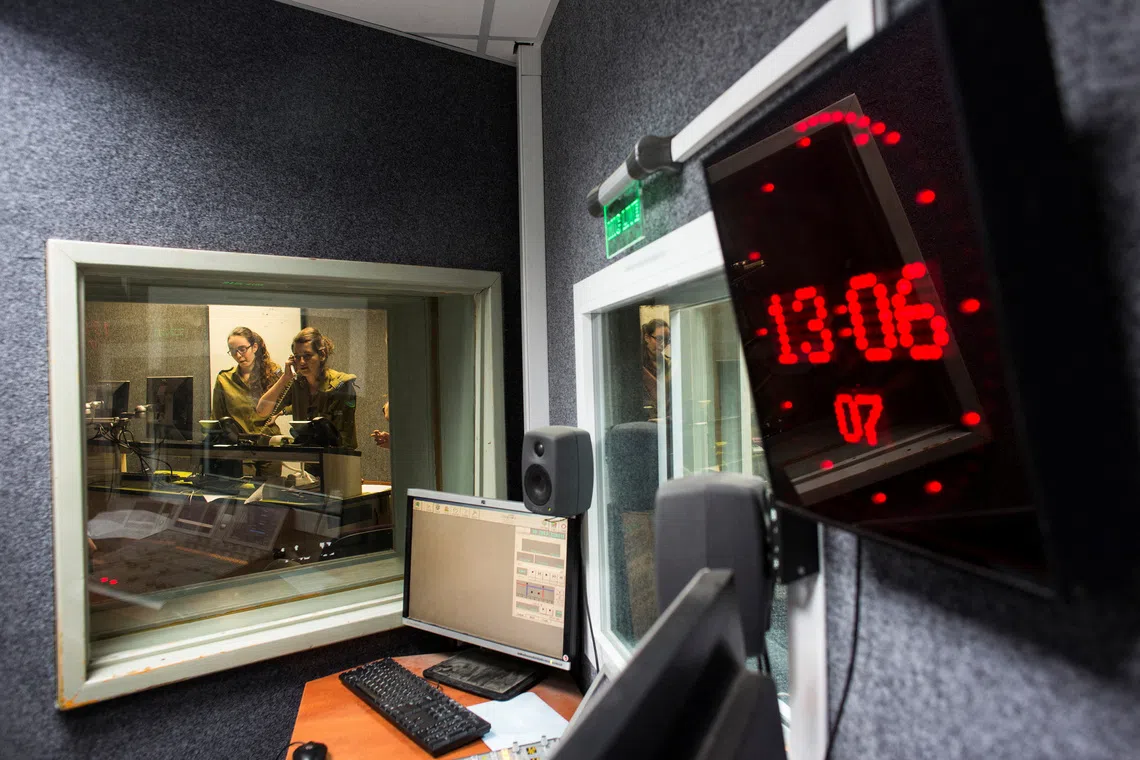 FILE PHOTO: Israeli soldiers from Galei Tzahal, the Israeli army radio station, are seen through a window while producing a show at the station's studio in Jaffa, south of central Tel Aviv November 10, 2013. REUTERS/Nir Elias/File Photo