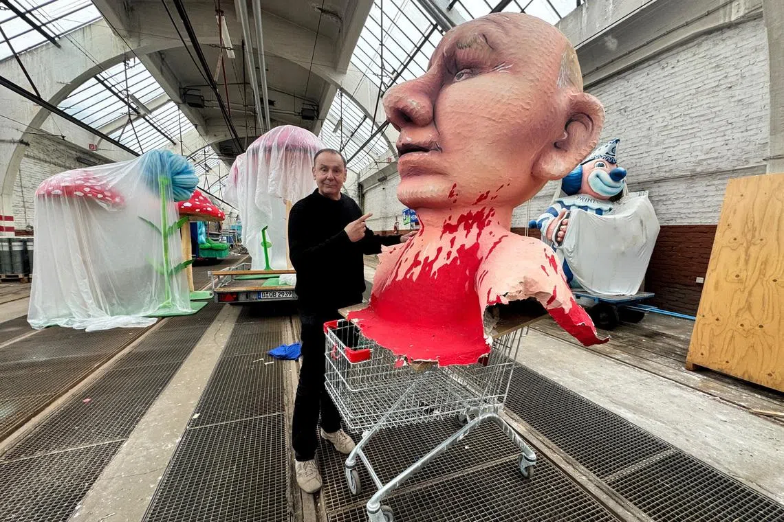 Jacques Tilly, a German sculptor and float builder famed for his provocative Carnival creations poses with a paper mache figure depicting Russian President Vladimir Putin in his workshop in Duesseldorf, Germany, April 2, 2026.    REUTERS/Petra Wischgoll