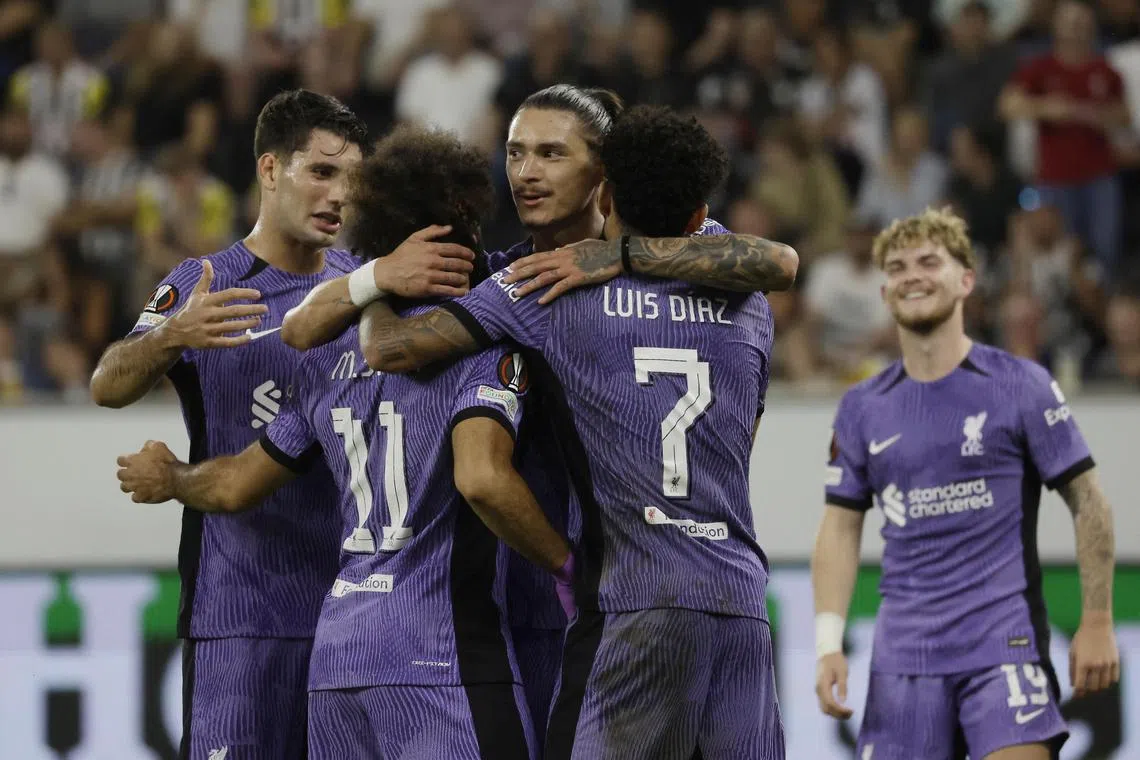 Liverpool's Mohamed Salah celebrates scoring their third goal with teammates.
