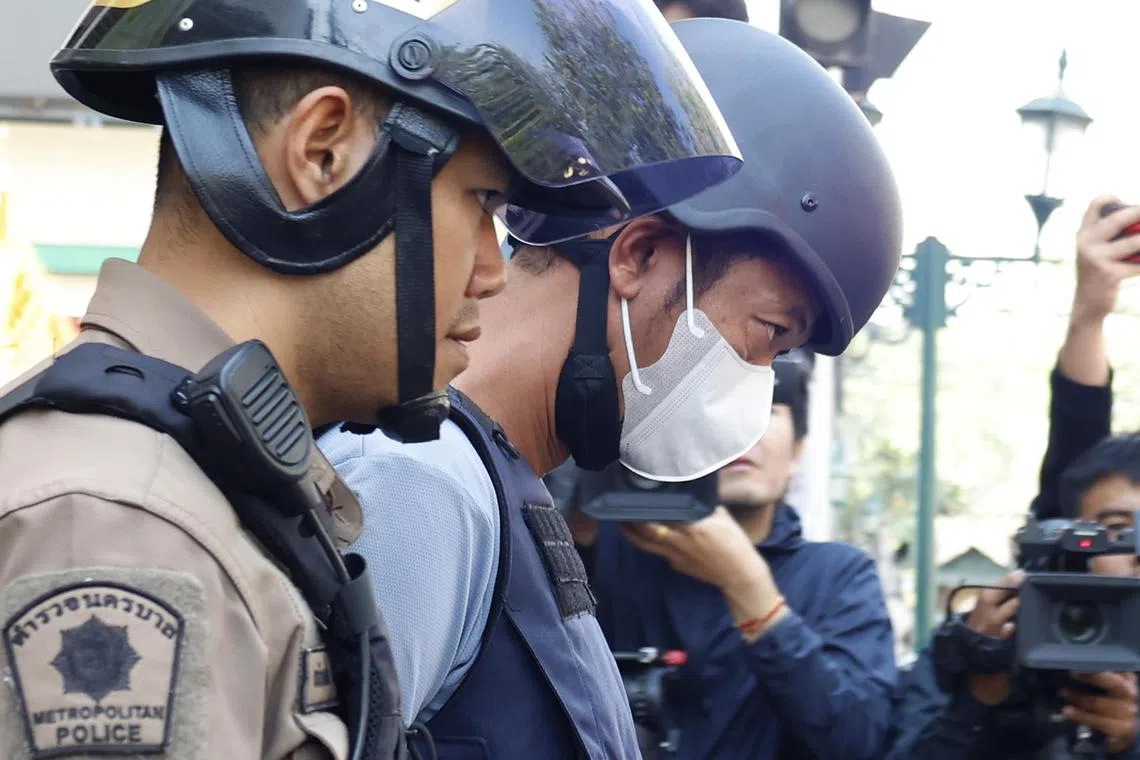 epa11821232 Thai national Ekalak Paenoi (R), a suspected gunman who allegedly killed former Cambodia opposition Member of Parliament Lim Kimya, is escorted by Thai police officers to court for remand, at Chana Songkhram police station in Bangkok, Thailand, 13 January 2025. According to the Royal Thai Police, cooperation between the Thai and Cambodian police led to the arrest of a Thai gunman who allegedly shot Lim Kimya, a former opposition Member of Parliament, in Bangkok on 07 January 2025.  EPA-EFE/NARONG SANGNAK