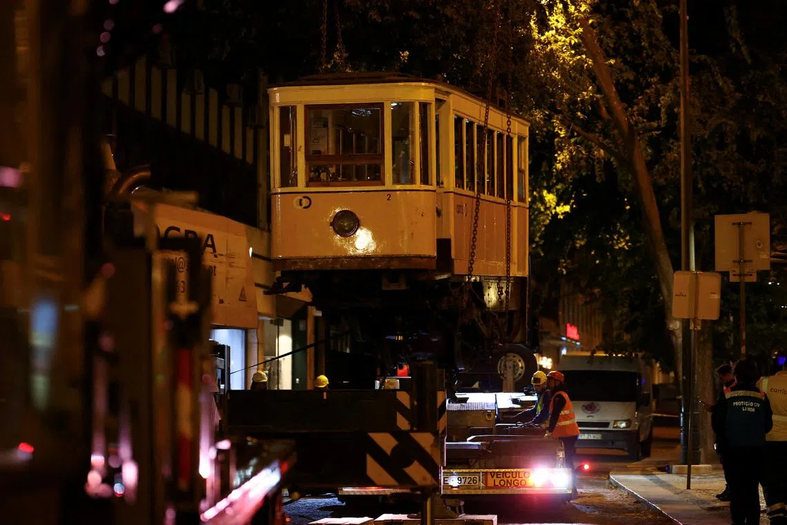 One of the funiculars is lifted, following derailment and crash of the Gloria funicular railway car, a popular tourist attraction, which resulted in multiple casualties, in Lisbon, Portugal, September 5, 2025. REUTERS/Pedro Nunes