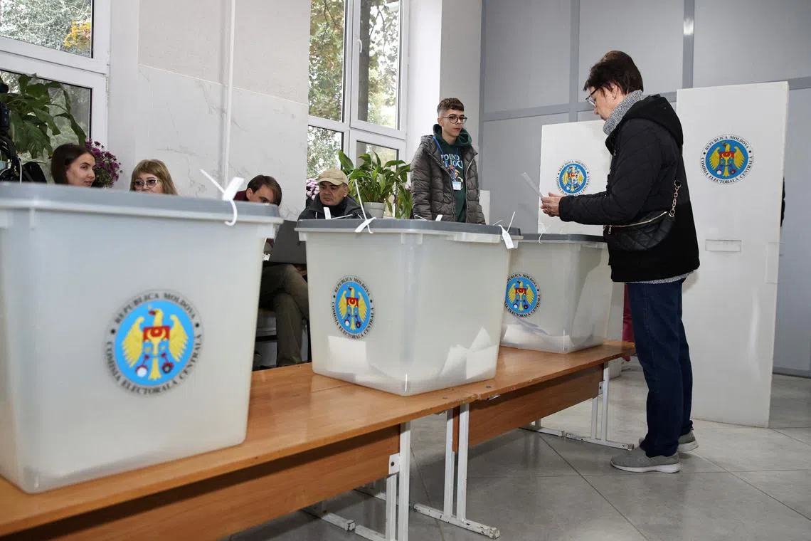 A voter casts a ballot at a polling station, as the country holds a presidential election and a referendum on joining the European Union, in Chisinau, Moldova October 20, 2024. REUTERS/Vladislav Culiomza
