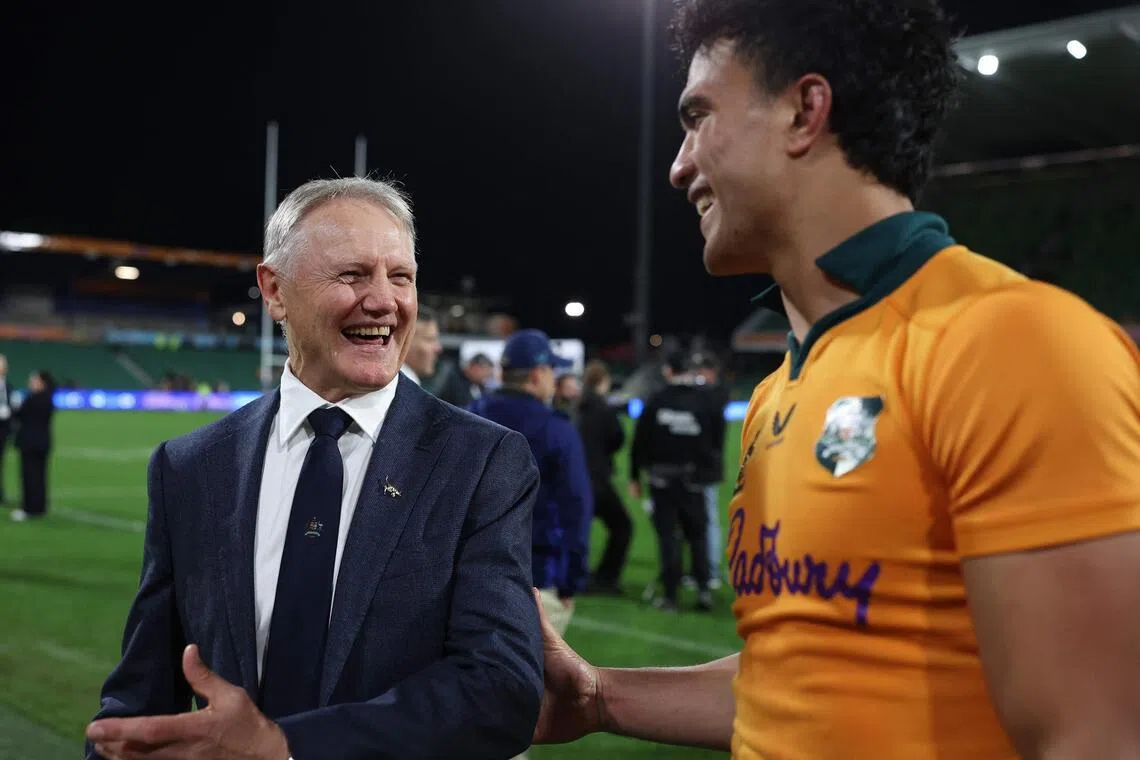 Australia's outgoing head coach Joe Schmidt (L) shares a smile with Australia's Joseph-Aukuso Suaalii after the rugby union Nations Championship match between Australia and Italy at HBF Park in Perth on July 18, 2026. (Photo by COLIN MURTY / AFP) / -- IMAGE RESTRICTED TO EDITORIAL USE - STRICTLY NO COMMERCIAL USE --