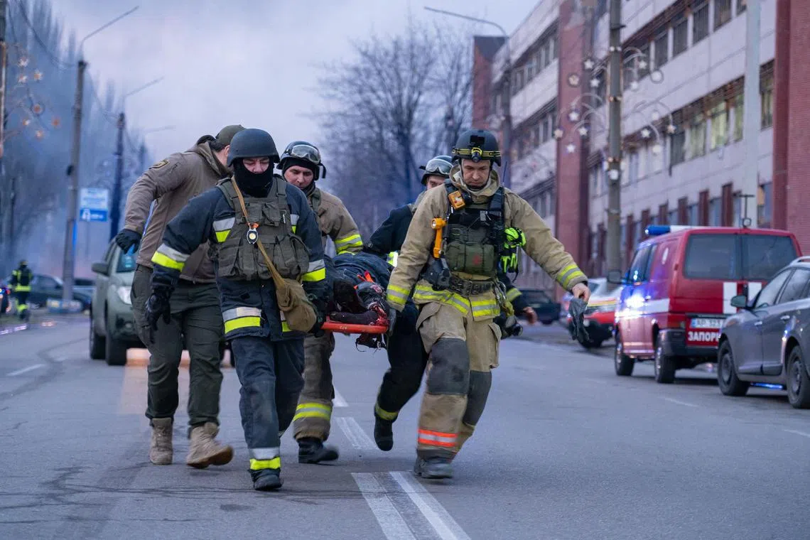 Rescuers carrying a wounded person at the site of a Russian air strike in the Ukrainian city of Zaporizhzhia, on Jan 8.