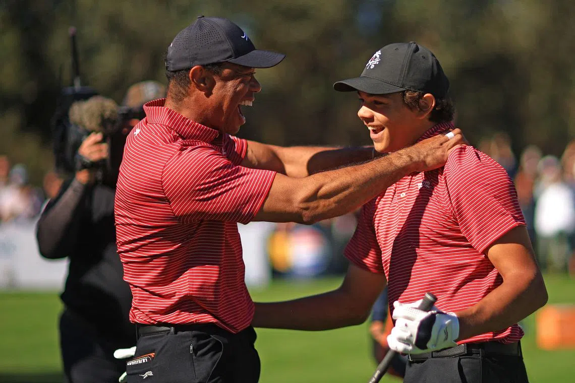 Tiger Woods congratulates son Charlie after he scored a hole-in-one on the 176-yard, par-3 No. 4 at the PNC Championship.